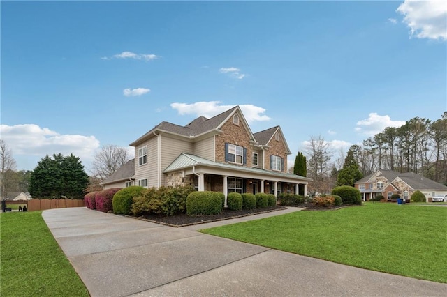 view of property exterior with fence, a yard, stone siding, and concrete driveway