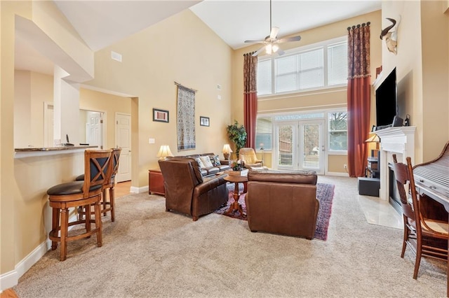 living room featuring a fireplace with flush hearth, high vaulted ceiling, baseboards, and carpet