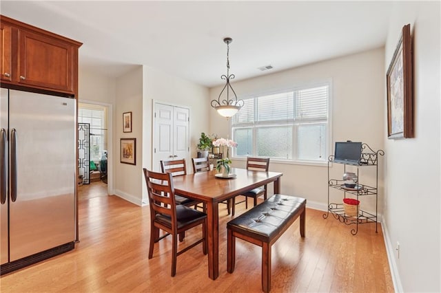 dining space featuring baseboards, plenty of natural light, light wood finished floors, and visible vents