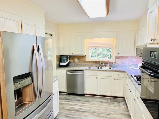31 Cline Dr SW, Cartersville, GA 30120 - kitchen featuring appliances with stainless steel finishes, a sink, backsplash, light wood-style floors, and light countertops