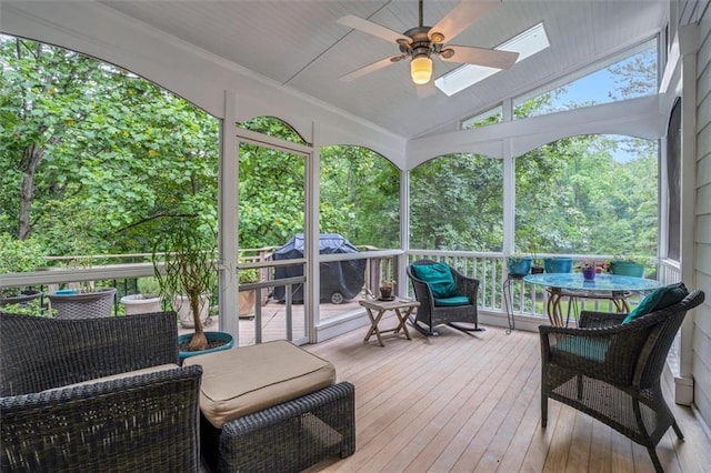 sunroom / solarium with ceiling fan and lofted ceiling with skylight