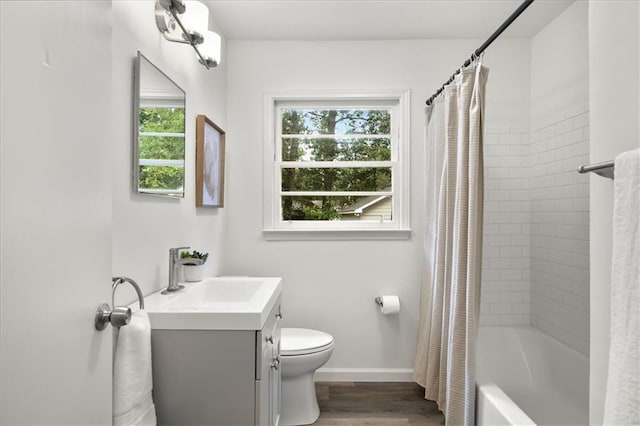 full bathroom featuring vanity, wood-type flooring, shower / bathtub combination with curtain, and toilet