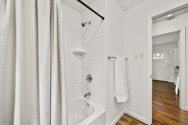 bathroom with hardwood / wood-style flooring and shower / tub combo