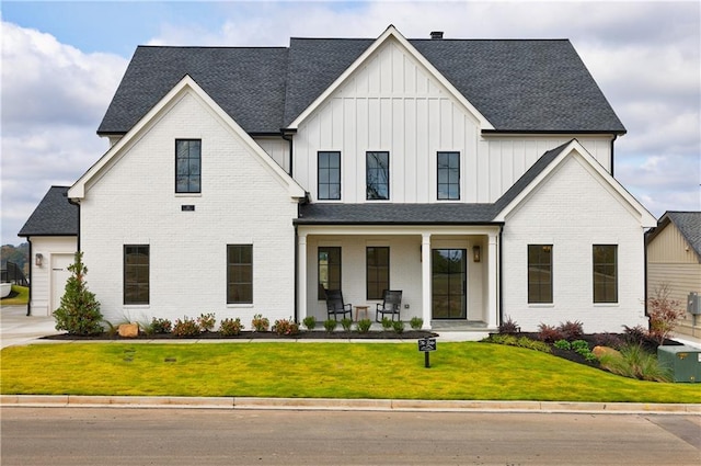 modern farmhouse style home featuring cooling unit, a garage, a front yard, and a porch