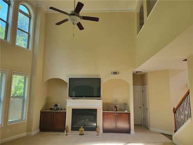 1080 Colgan Ct, Alpharetta, GA 30004 - living room featuring a high ceiling, a glass covered fireplace, ceiling fan, light carpet, and stairs