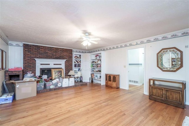 1526 N Cherokee Rd N, Social Circle, GA 30025 - unfurnished living room with a brick fireplace, wood finished floors, a ceiling fan, a textured ceiling, and baseboards