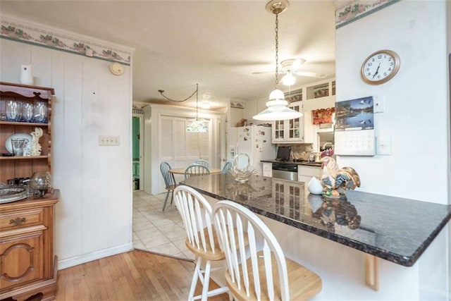 1526 N Cherokee Rd N, Social Circle, GA 30025 - kitchen featuring white refrigerator with ice dispenser, a kitchen breakfast bar, a ceiling fan, and pendant lighting
