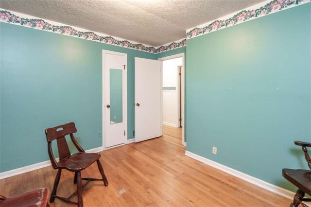 1526 N Cherokee Rd N, Social Circle, GA 30025 - living area with a textured ceiling, wood finished floors, and baseboards
