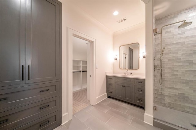 full bathroom featuring a shower stall, vanity, tile patterned floors, ornamental molding, and baseboards