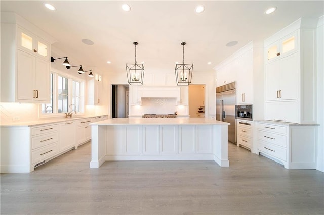 kitchen with stainless steel appliances, decorative backsplash, a center island, white cabinetry, and recessed lighting