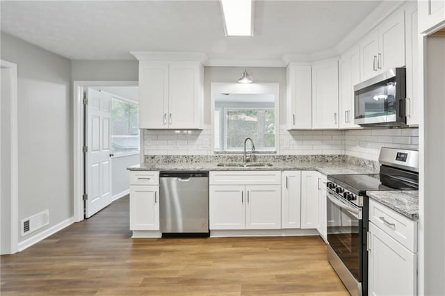 kitchen featuring white cabinetry, sink, stainless steel appliances, and light wood-type flooring