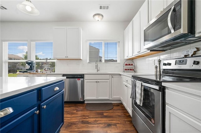 1560 Avalon Creek Rd, Sugar Hill, GA 30518 - kitchen with stainless steel appliances, blue cabinets, decorative backsplash, dark wood-type flooring, and light countertops
