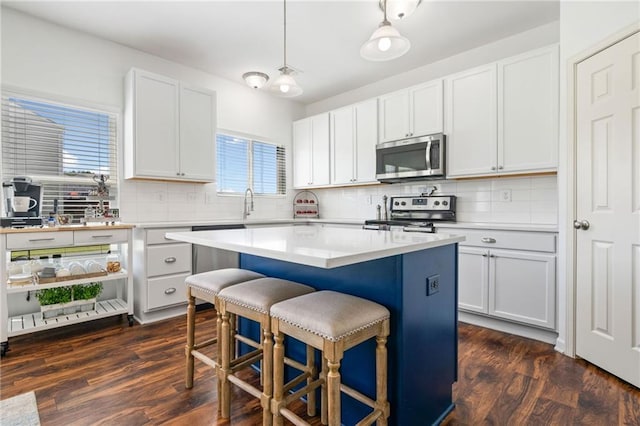 1560 Avalon Creek Rd, Sugar Hill, GA 30518 - kitchen featuring stainless steel appliances, a breakfast bar, backsplash, a kitchen island, and dark wood-style floors