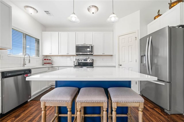 1560 Avalon Creek Rd, Sugar Hill, GA 30518 - kitchen featuring stainless steel appliances, dark wood-style floors, a breakfast bar, and decorative backsplash