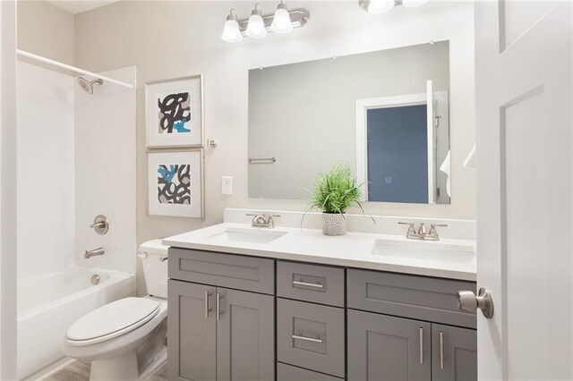 bathroom featuring a sink, bathing tub / shower combination, toilet, and double vanity