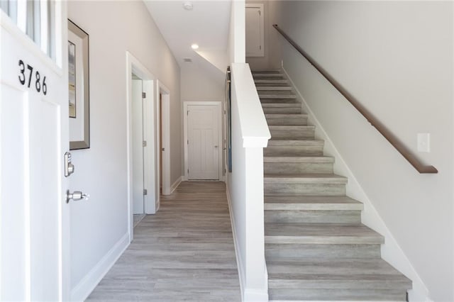 stairway featuring wood finished floors and baseboards