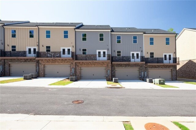 townhome / multi-family property with a front yard and stone siding