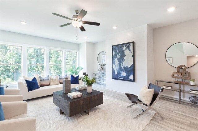 living room with light wood-style floors, baseboards, and recessed lighting