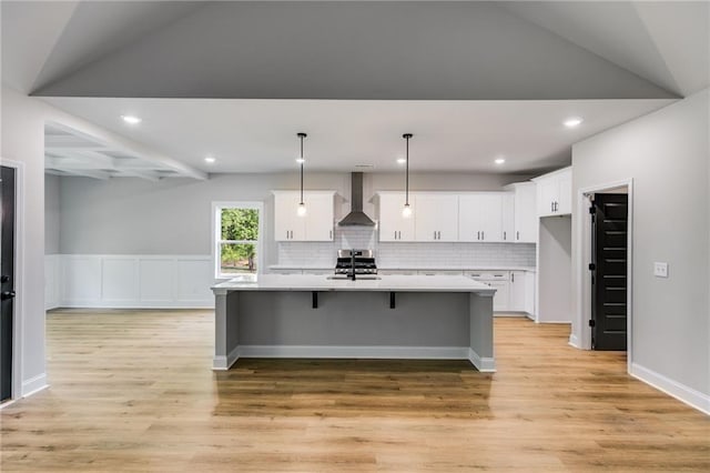 8971 Callaway Dr, Winston, GA 30187 - kitchen with light countertops, white cabinets, light wood finished floors, and wall chimney exhaust hood