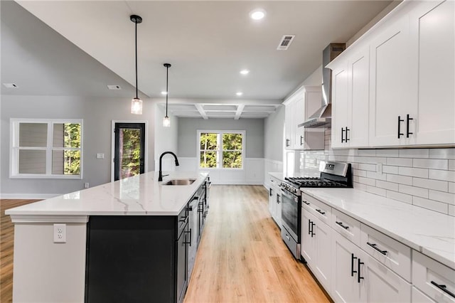 8971 Callaway Dr, Winston, GA 30187 - kitchen with a kitchen island with sink, gas range, a sink, light wood finished floors, and wall chimney exhaust hood