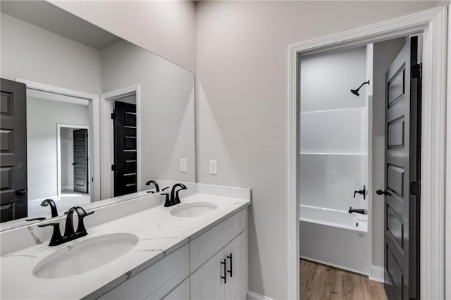 8971 Callaway Dr, Winston, GA 30187 - full bathroom with a sink, washtub / shower combination, double vanity, and wood finished floors