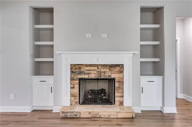 8971 Callaway Dr, Winston, GA 30187 - unfurnished living room with a stone fireplace, baseboards, wood finished floors, and built in shelves