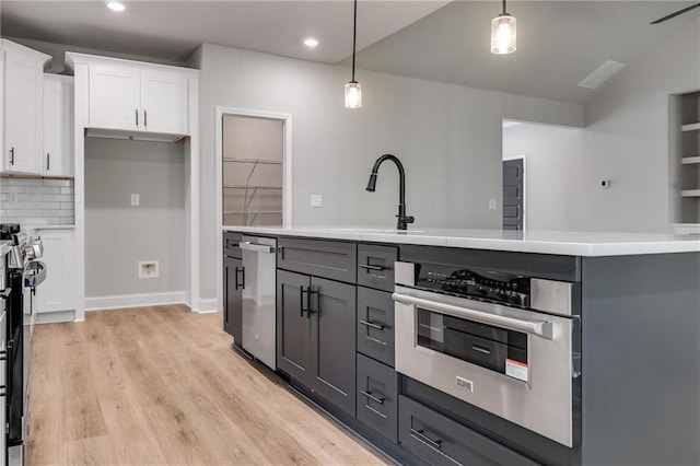 8971 Callaway Dr, Winston, GA 30187 - kitchen with appliances with stainless steel finishes, hanging light fixtures, light wood-type flooring, light countertops, and white cabinets