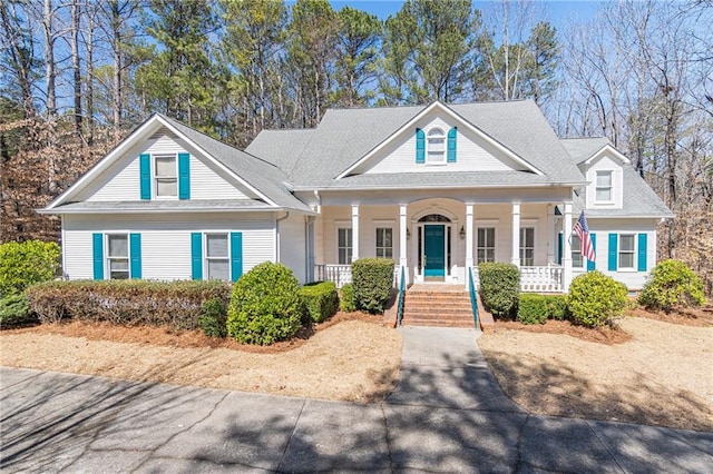 neoclassical home featuring a porch and roof with shingles