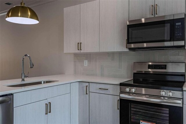 kitchen featuring kitchen peninsula, decorative light fixtures, stainless steel appliances, and a healthy amount of sunlight