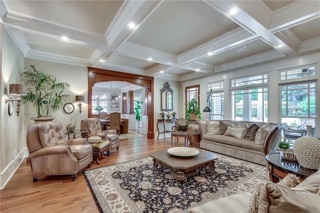 living room featuring beam ceiling, light hardwood / wood-style floors, coffered ceiling, and crown molding