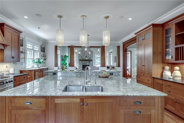 kitchen with hanging light fixtures, ornamental molding, and sink