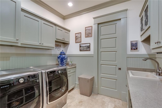 laundry area with cabinets, crown molding, washer and dryer, and sink