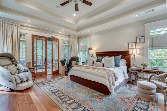 bedroom with a raised ceiling, light wood-type flooring, ceiling fan, access to outside, and ornamental molding