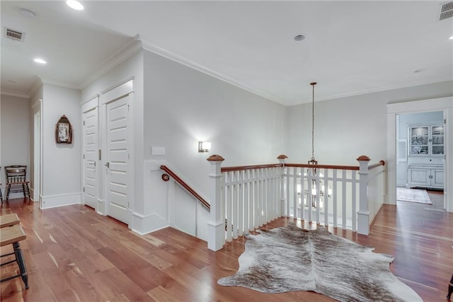 corridor featuring wood-type flooring and ornamental molding