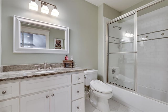 full bathroom featuring tile patterned floors, bath / shower combo with glass door, vanity, and toilet