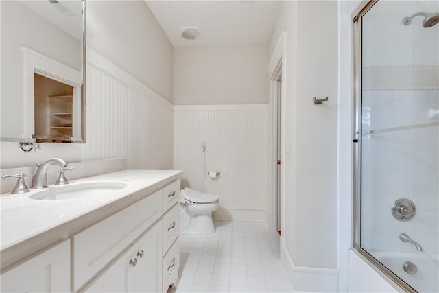 full bathroom featuring tile patterned floors, combined bath / shower with glass door, vanity, and toilet