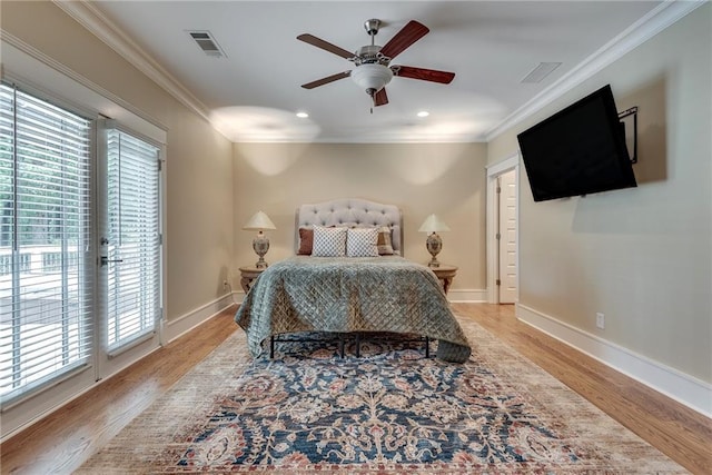 bedroom featuring ceiling fan, light hardwood / wood-style flooring, ornamental molding, and multiple windows