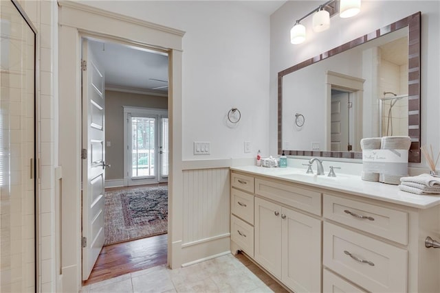 bathroom with ornamental molding, wood-type flooring, an enclosed shower, and vanity