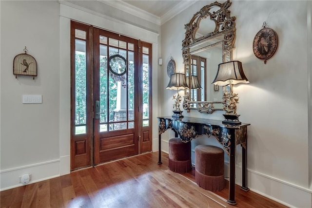 foyer entrance featuring wood-type flooring, ornamental molding, and a wealth of natural light