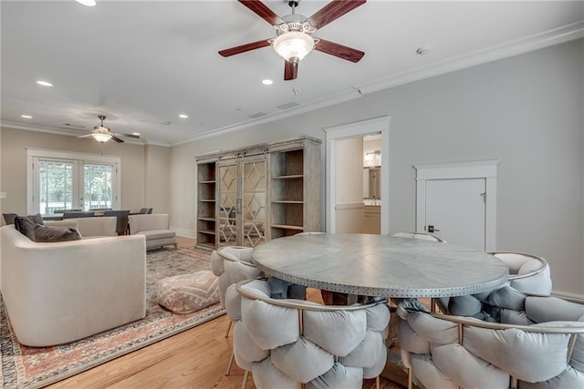 dining space featuring ceiling fan, light hardwood / wood-style flooring, and ornamental molding