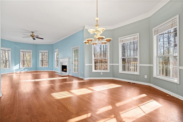 interior space featuring wood-type flooring, ceiling fan with notable chandelier, and ornamental molding