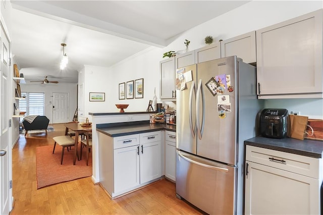 3675 Peachtree Rd NE Unit 24, Atlanta, GA 30319 - kitchen featuring freestanding refrigerator, a peninsula, dark countertops, ceiling fan, and light wood-type flooring