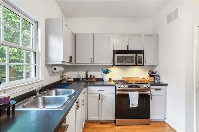 3675 Peachtree Rd NE Unit 24, Atlanta, GA 30319 - kitchen with stainless steel appliances, dark countertops, and light wood-style flooring