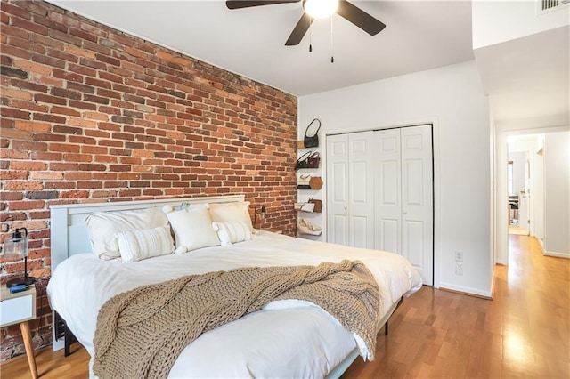3675 Peachtree Rd NE Unit 24, Atlanta, GA 30319 - bedroom featuring a closet, brick wall, wood finished floors, and ceiling fan