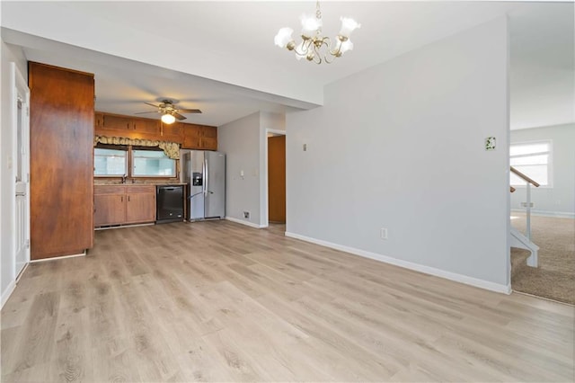 unfurnished living room featuring ceiling fan with notable chandelier, light hardwood / wood-style flooring, and sink