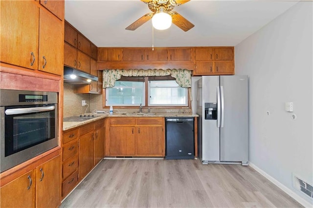 kitchen with black appliances, decorative backsplash, light hardwood / wood-style floors, sink, and ceiling fan