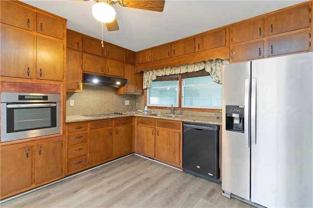 kitchen with black appliances, light hardwood / wood-style floors, sink, ceiling fan, and light stone counters