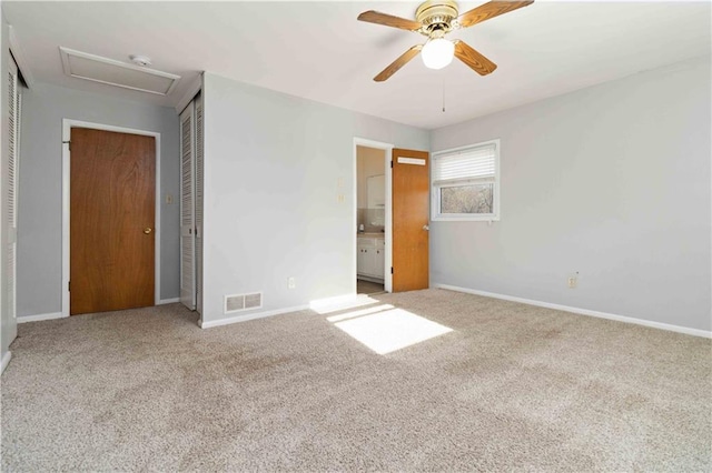 unfurnished bedroom with ceiling fan, ensuite bathroom, and carpet floors