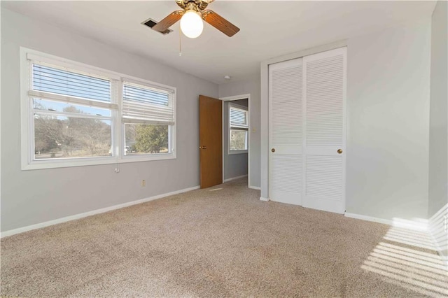 unfurnished bedroom featuring ceiling fan, a closet, and carpet