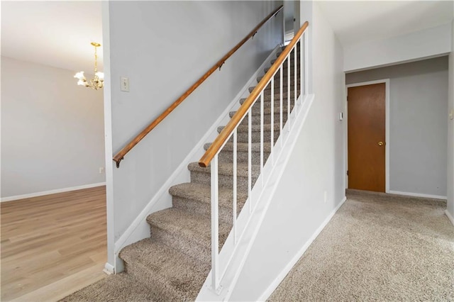 staircase featuring carpet and a notable chandelier